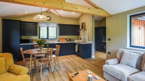 A spacious living area with a dining table, chairs, a sofa, and a coffee table. - Poplar Lodge - UK50625 (Welshpool)