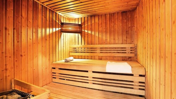 A wooden sauna with benches and a bench seat, a bench seat with a towel, and a bench with a towel. - 2 Rooms 4 People (Locmaria-Plouzane)