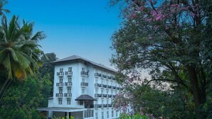 A multi-story hotel with balconies, surrounded by lush greenery and trees. - BPR Asgiriya (Kandy)