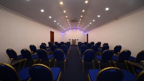 A conference room with rows of blue chairs and a podium at the front. - BPR Asgiriya (Kandy)