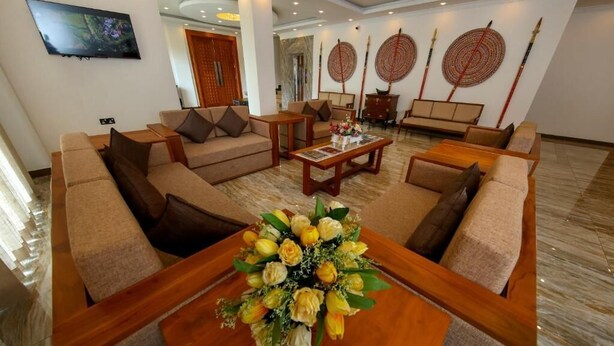 A spacious hotel lobby with sofas, a coffee table with a floral centerpiece, and traditional decor. - BPR Asgiriya (Kandy)