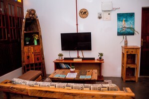A living room with a wooden coffee table, a television, a bookshelf, and a door.