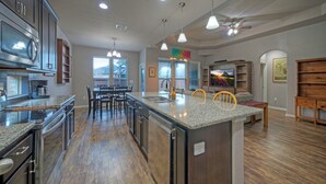 Una cocina moderna con encimeras de granito, electrodomésticos de acero inoxidable y una isla central.