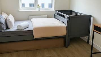 Ein Zimmer mit einem Bett, einem Fenster und Blick auf Gebäude.