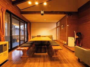 Una habitación acogedora con una mesa de madera, bancos y vistas a través de un ventanal.