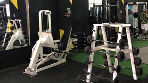 Un gimnasio con equipo de ejercicio, un espejo y una ventana.