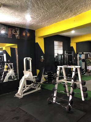 A gym with exercise equipment, a mirror, and a window. - Modern Comfort Stay Una Estancia Moderna y Confortable (Puerto Plata)