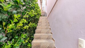 Una escalera estrecha con baldosas decorativas que sube a una puerta.