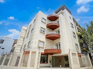 Un immeuble à plusieurs étages doté de balcons, de grandes fenêtres et d’un toit plat.