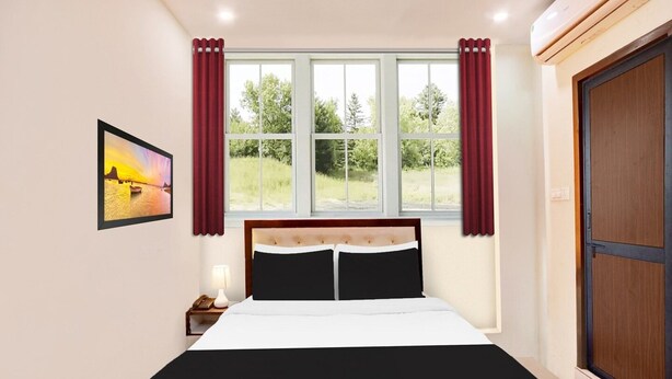 A bedroom with a bed, a nightstand, a lamp, a window with curtains, and a painting on the wall. - Super Hotel O MVP Double Road (Visakhapatnam)