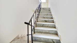 A staircase with marble steps and black metal railings leading to a landing. - Super Hotel O MVP Double Road (Visakhapatnam)