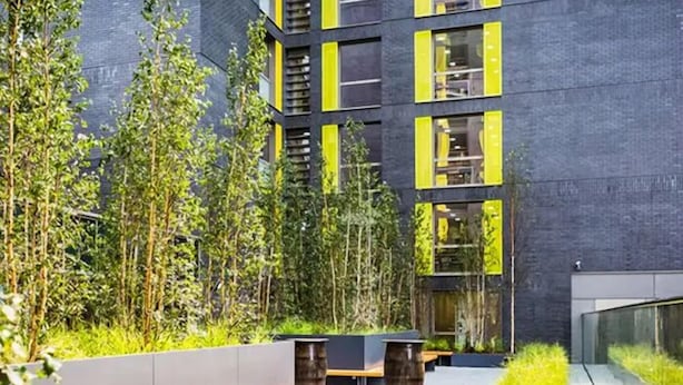 A modern building with vertical gardens, outdoor seating, and a pathway. - Student Only Studio Chapter Lewisham (London)