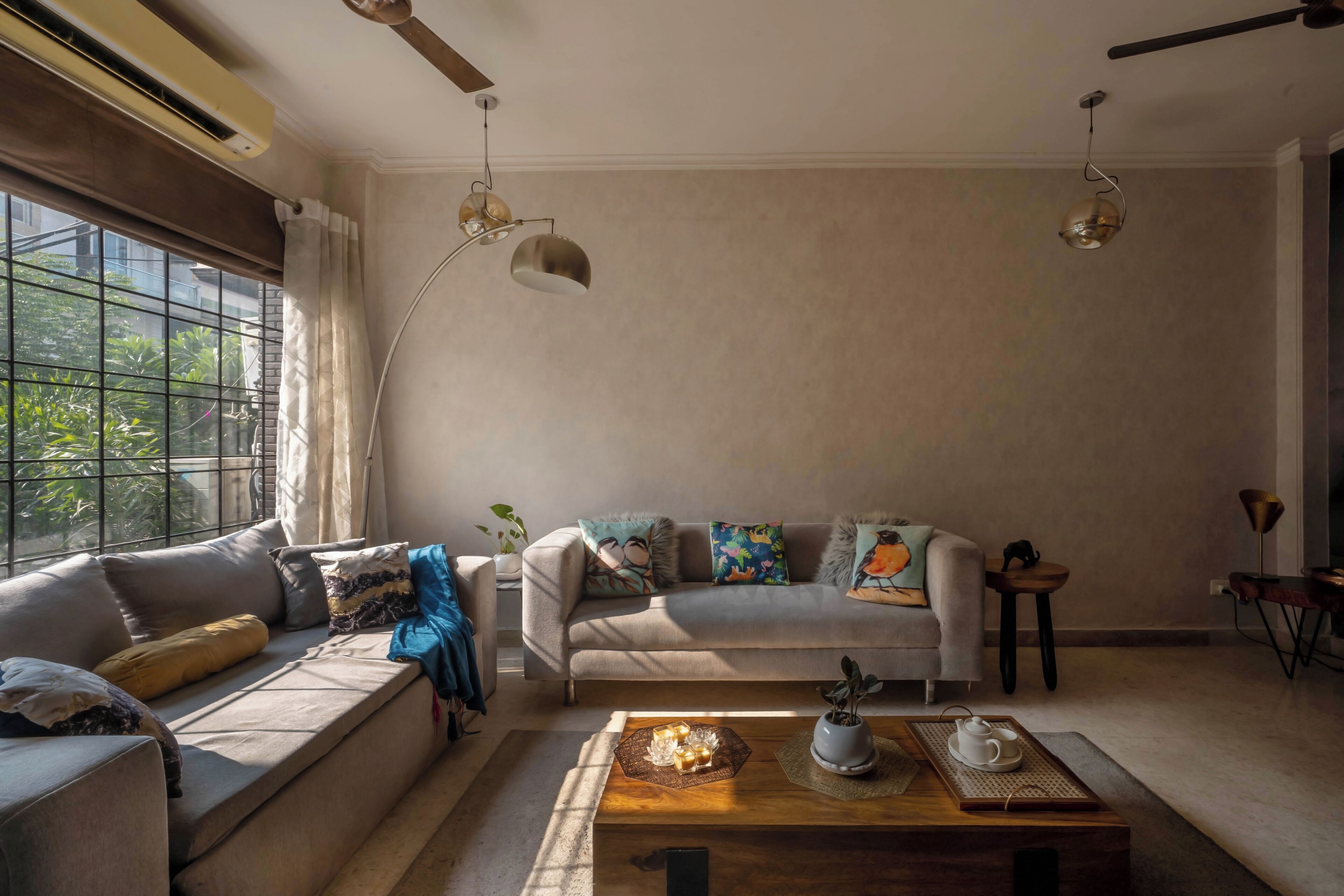 A living room with a sofa, coffee table, and pendant lights.