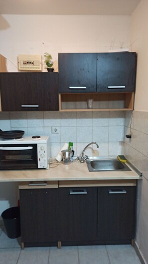 A compact kitchen with a microwave, sink, and cabinets. - Studio Heart of City , Electric Scouter (Thessaloniki)