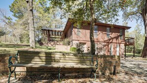 A wooden cabin with a porch, a bench, and a surrounding wooded area. - Near Bruce's Field, Downtown & Hospital! Cozy Unit (Aiken)