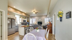 A modern kitchen with a dining area, wooden flooring, and a ceiling fan. - Richland Home on Multi-Unit Farm: Fish, Hike! (Richland)