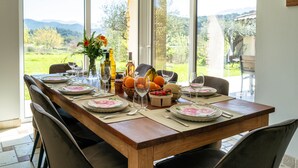 Mesa de jantar posta para seis pessoas, com vista para o exterior.