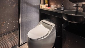 A modern bathroom with a toilet, sink, and mirror. - Yangshuo B&G Hotel (Guilin)
