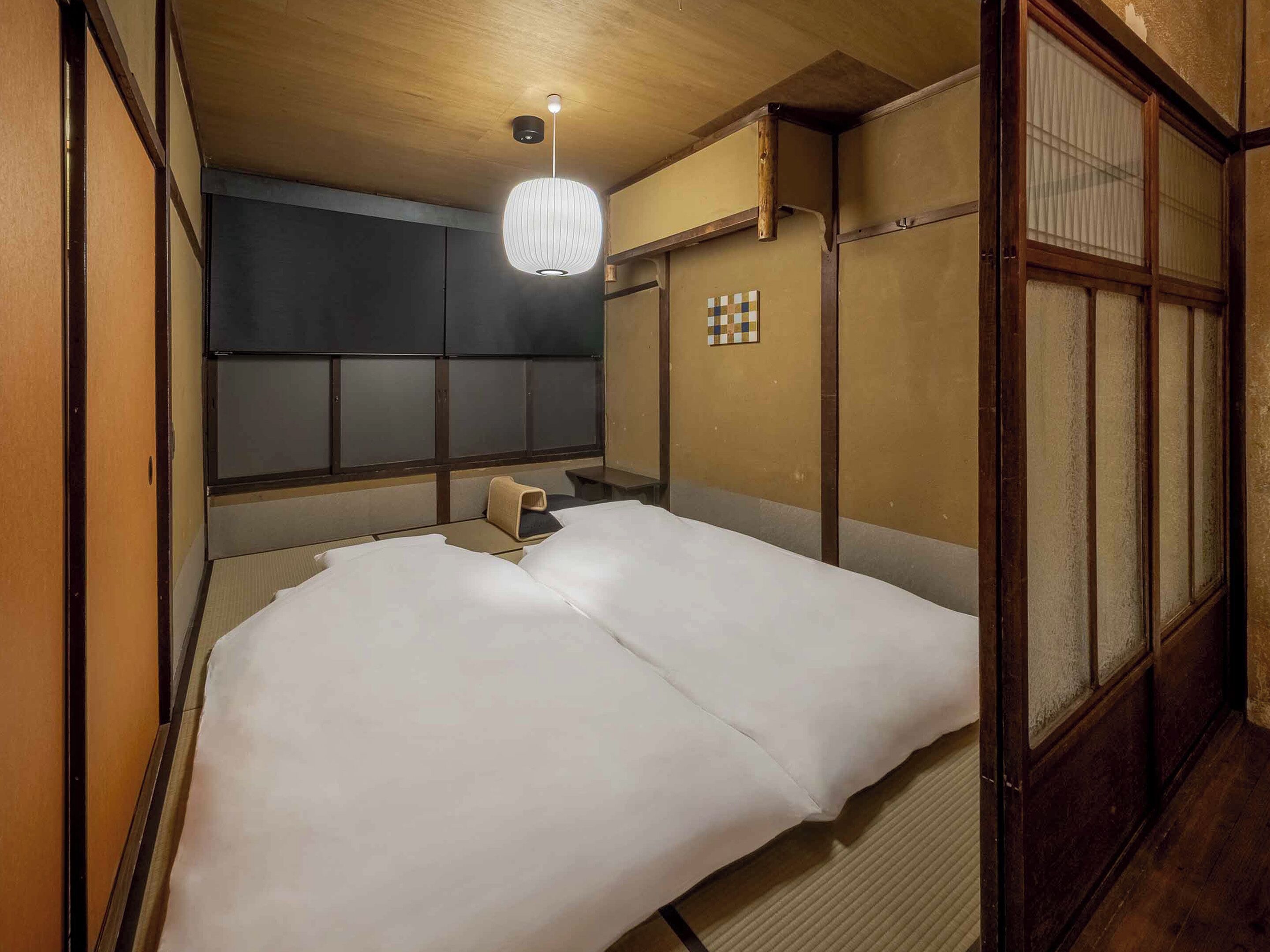 Une pièce de style japonais traditionnel, avec un sol recouvert de tatamis, un plafond bas en bois et une porte coulissante en papier de riz (shoji).