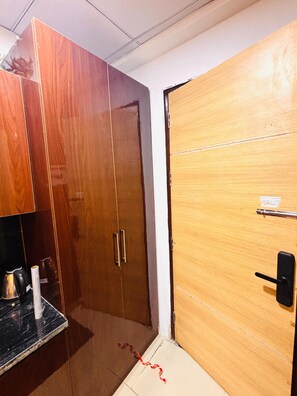 Ein Zimmer mit einem Holzschrank, einer schwarzen Arbeitsplatte und einer Tür mit Griff.
