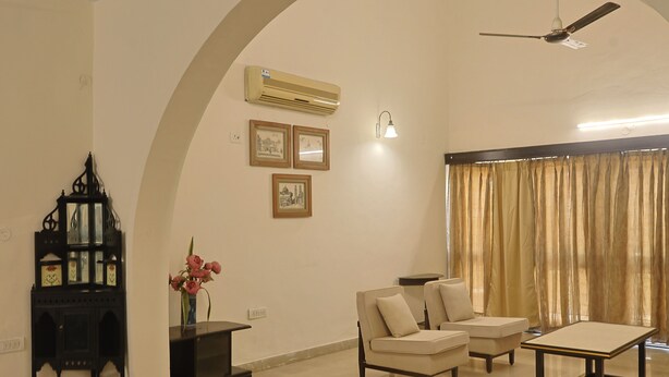 Una sala de estar con sofá, mesa de centro, mueble para televisión y aparador decorativo.