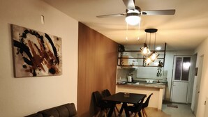 Ein Wohnzimmer mit Sofa, Couchtisch und Essbereich mit Stühlen.