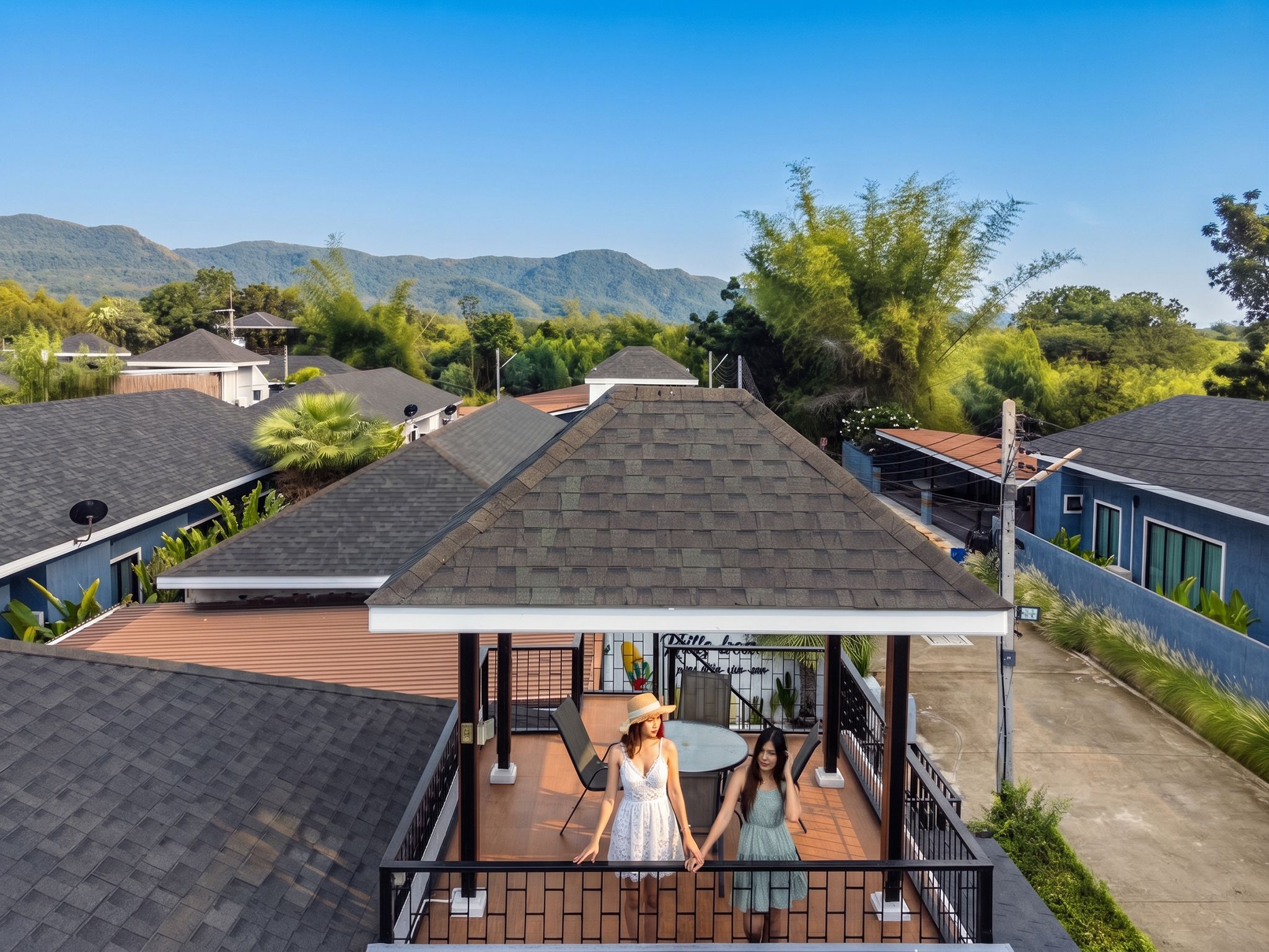 Un barrio residencial con varias casas, una zona de estar al aire libre techada y montañas al fondo.