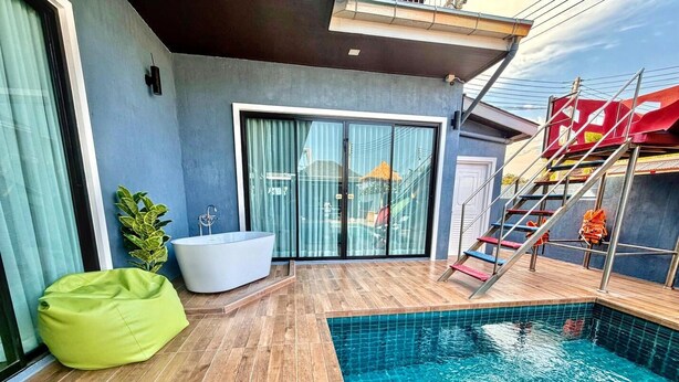 A modern outdoor pool area with a wooden deck, a large bathtub, and a staircase leading to a covered area. - For You Breeze Casa Private Pool Villa with 3 bedrooms, Near Cha-Am Beach (Khao Yai)
