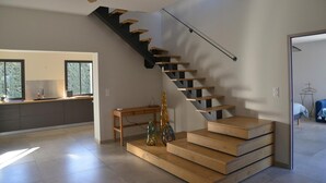 A modern interior with a staircase, a wooden bench, and decorative bottles. - Gorgeous Mansion for 6 in Barjac (Barjac)