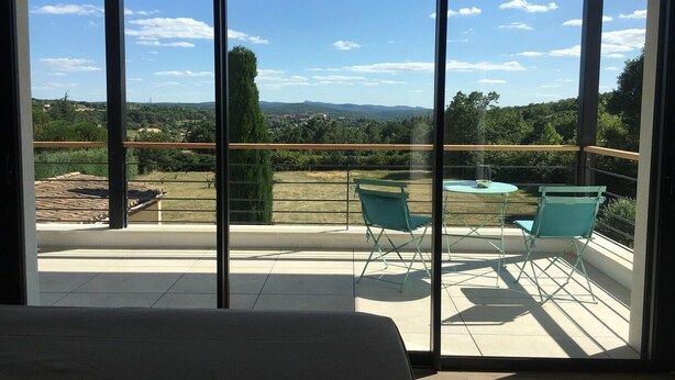 A balcony with a view of a landscape, a table, and two chairs. - Gorgeous Mansion for 6 in Barjac (Barjac)