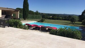 A swimming pool with lounge chairs, a barbecue area, and a view of the countryside. - Gorgeous Mansion for 6 in Barjac (Barjac)