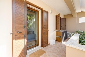 A room with a sliding glass door, a small seating area, a fan, and a water dispenser. - Apartment with air conditioning (Tergu)