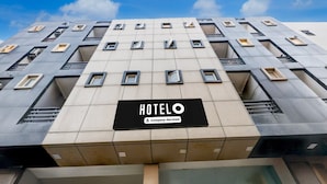 Een hotelgebouw met een moderne gevel, meerdere ramen en een bord dat aangeeft dat het dienstverlenend is voor bedrijven.