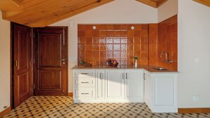A kitchen with wooden cabinets, a tiled backsplash, and a wooden ceiling. - Konifer Villas By ELIVAAS (Kasauli)