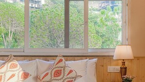 A bedroom with a large window, wooden ceiling, and a bed with patterned pillows. - Konifer Villas By ELIVAAS (Kasauli)