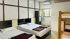 A hotel room with two beds, a ceiling fan, and a window with curtains. - Hotel Gananjaya Gokarna (Gokarna)
