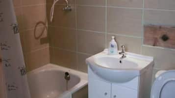 Een badkamer met een bad, een wastafel en een toilet.