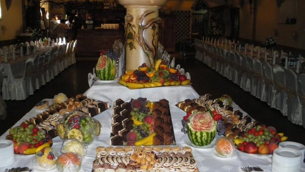 A buffet table with various food items and a central decorative pillar. - Impresja Krasiczyn (Krasiczyn)