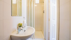 Une salle de bain avec un lavabo, un miroir et une douche.