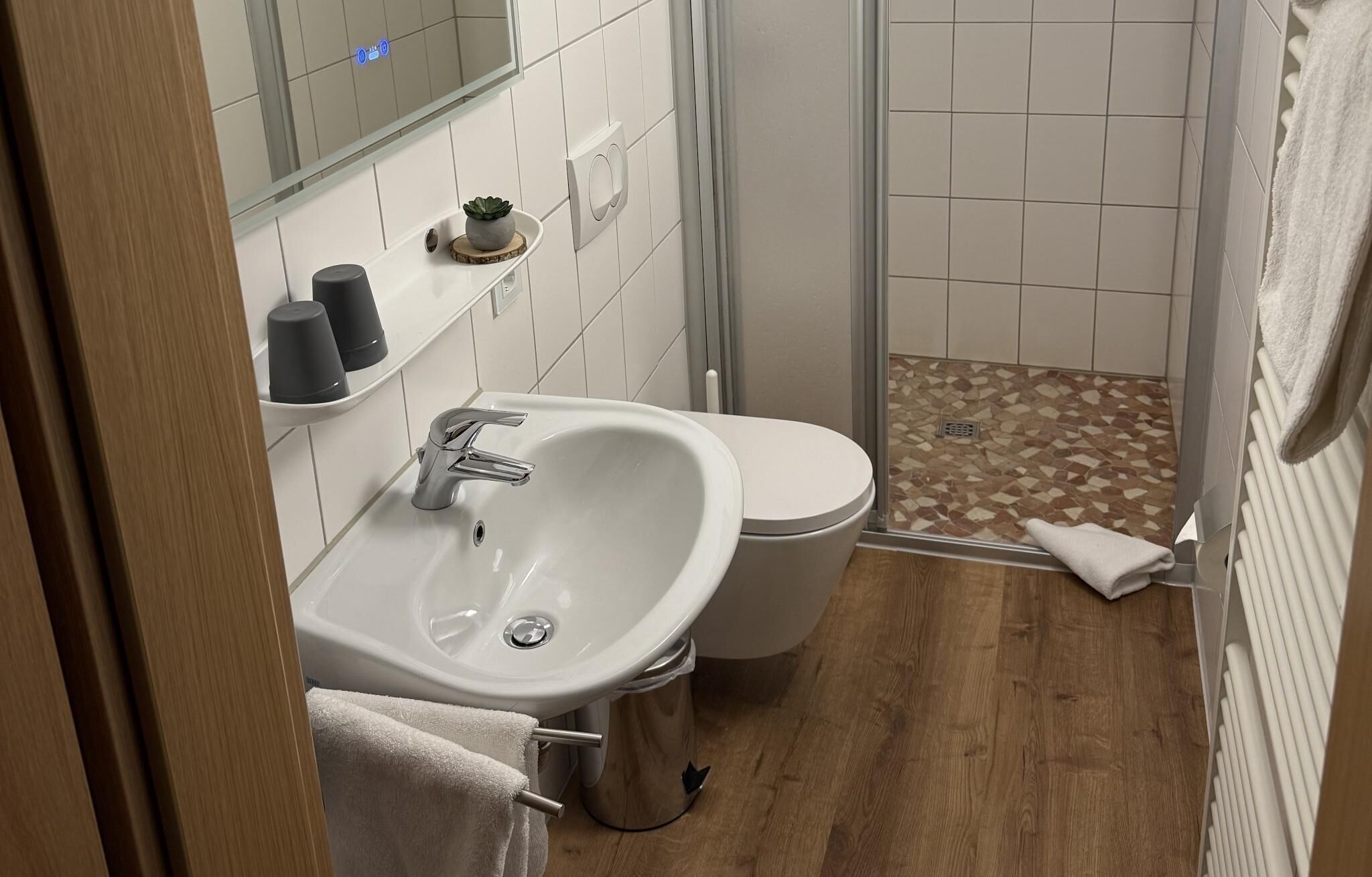 A bathroom with a sink, toilet, and shower area.