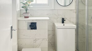 Un bagno con WC, lavabo e doccia.