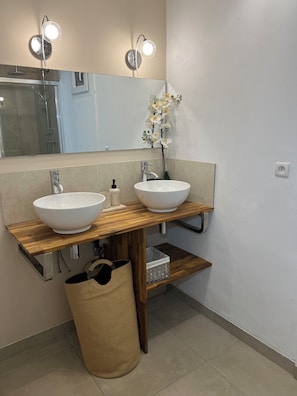 Ein Badezimmer mit zwei Waschbecken, einem Spiegel und einer Dusche.