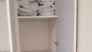 Um guarda-roupa com várias prateleiras, um espaço para pendurar roupas e uma gaveta.