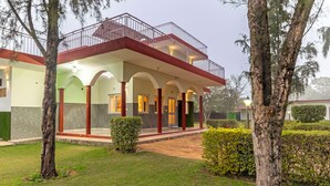Ein Gebäude mit überdachter Terrasse, Säulen und einem Balkon.