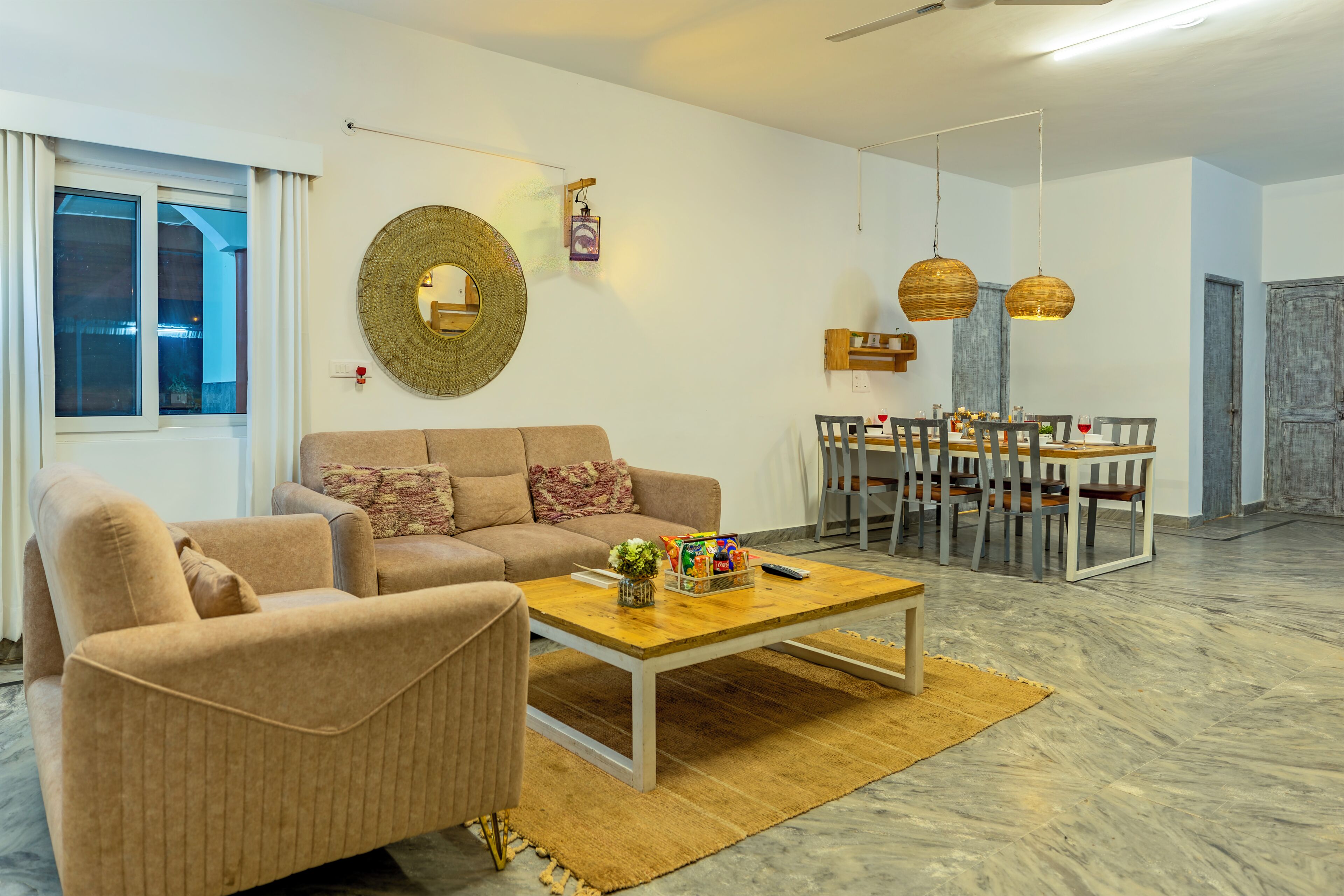 Ein Wohnzimmer mit einer Couch, einem Couchtisch und einem Essbereich mit Stühlen und einem Tisch.