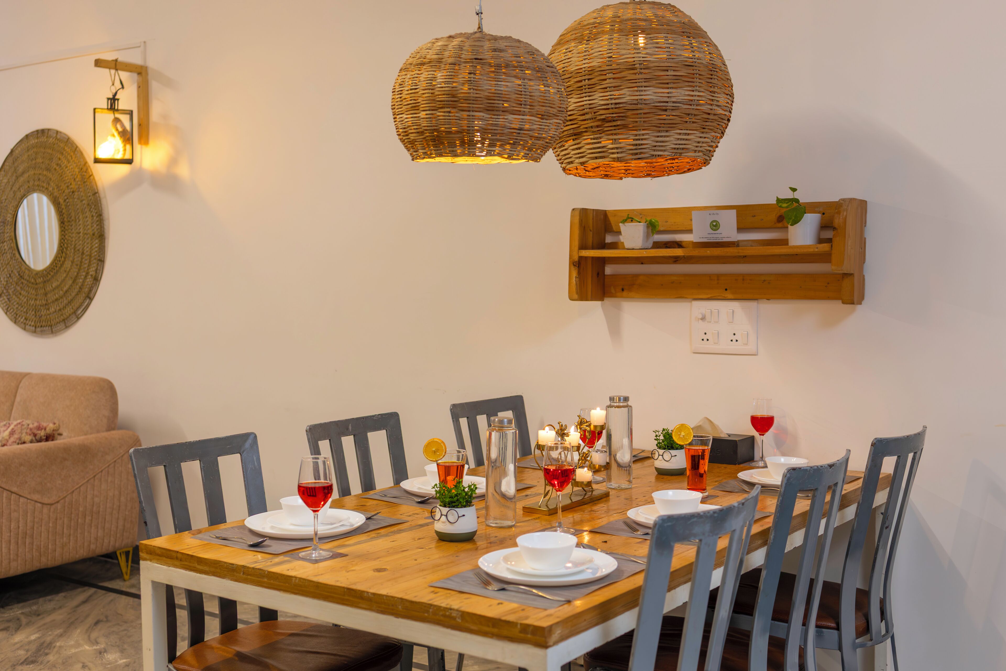 A dining area with a wooden table, chairs, and hanging wicker lamps.