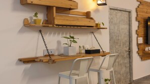 Ein Zimmer mit einer Holzhockerregal, einem weißen Stuhl und einem kleinen Tisch mit einer Pflanze.