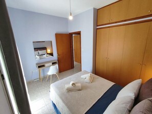A bedroom with a bed, a desk, a chair, and a wardrobe. - Overlooking the Tower by RentalsPro - Nea Fokea Halkidiki (Nea Fokea)