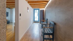 A hallway with wooden beams, a bench, and a door leading to another room. - Nice apartment for 5 guests with A/C, WIFI and patio (Magugnano)