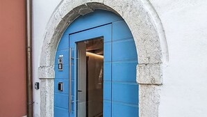 A blue door with a keypad lock, an elevator, and a stone archway. - Nice apartment for 5 guests with A/C, WIFI and patio (Magugnano)